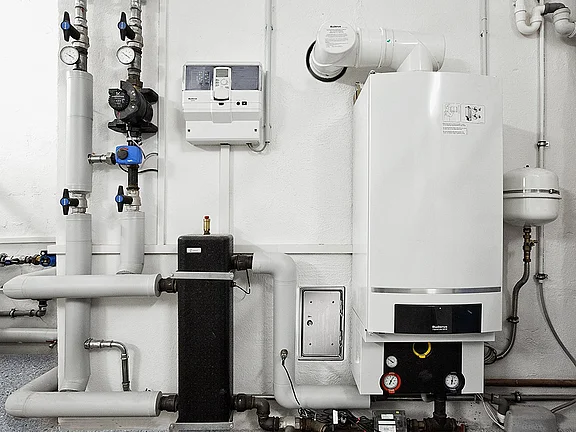 Moderne Heizungsanlage mit Wärmeerzeuger, Leitungen und Messgeräten in einem Technikraum